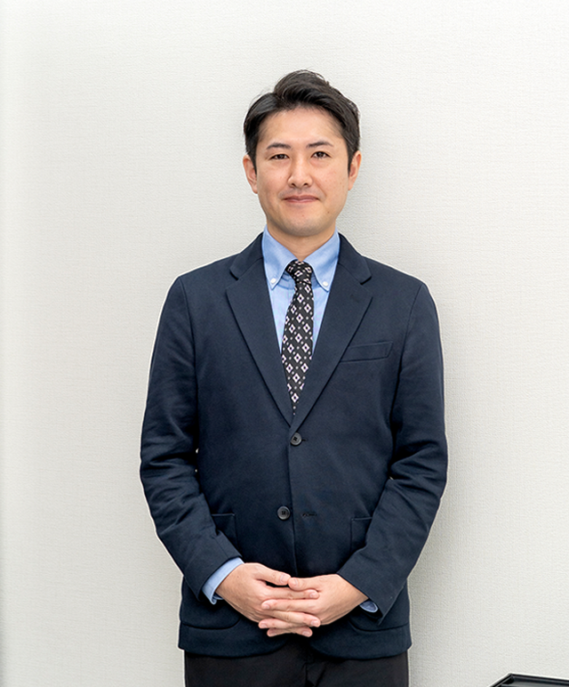 挨拶をするVサインの店長