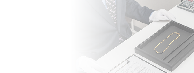 鑑定する買取Vサインのスタッフ