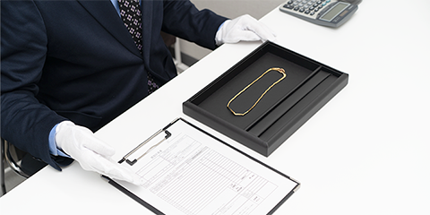 買取価格を提示するVサインのスタッフ